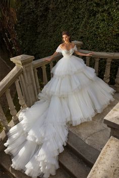 a woman in a white dress standing on some stairs