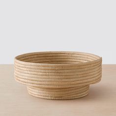 a large woven basket sitting on top of a wooden table