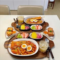 a table topped with plates and bowls filled with different types of food next to drinks