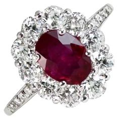 Edwardian-inspired Natural Oval Ruby Ring featuring a 1.05-carat oval-cut natural ruby surrounded by a halo of old mine-cut diamonds in a floral head motif. Pave-set diamonds adorn the shoulders. The total diamond weight is around 1.50 carats. This Natural Oval Ruby Ring is Crafted in platinum with openwork under the gallery. Ring Size: 6.5 US, Resizable Metal: Platinum Stone: Diamond, Ruby Stone Cut: Oval Cut Style: Edwardian Total Weight: 3.83 Grams Gia Certified Oval Ruby Ring, Luxury Oval Ruby Ring With Halo Design, Red Oval Cluster Ring With Rose Cut Diamonds, Gia Certified Heirloom Oval Ruby Ring, Heirloom Oval Ruby Ring Gia Certified, Heirloom Oval Gia Certified Ruby Ring, Oval Ruby Halo Ring With Brilliant Cut, Oval Ruby Cluster Ring With Rose Cut Diamonds, Oval Ruby Ring With Rose Cut Diamonds