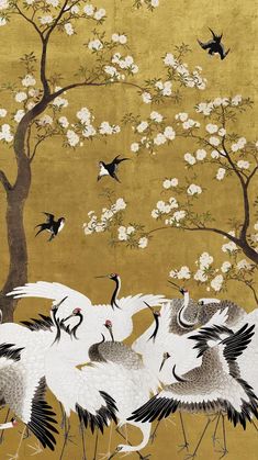 four cranes are standing in front of a tree with white flowers and birds flying around