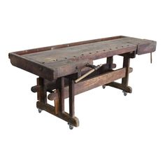 an old wooden table with wheels on it