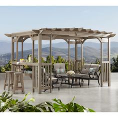 a wooden gazebo sitting on top of a patio next to a table and chairs