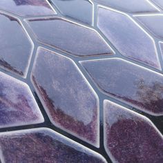 a close up view of the surface of a glass mosaic tile pattern with purple and blue colors