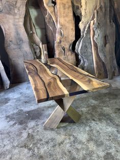 a table made out of wood with metal legs and a wooden slab in the middle