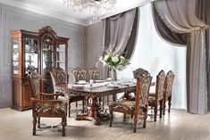 a dining room table with chairs, china cabinet and chandelier in the corner