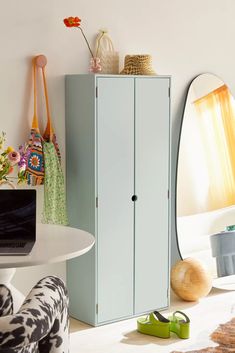 a blue cabinet sitting in the corner of a living room next to a white table