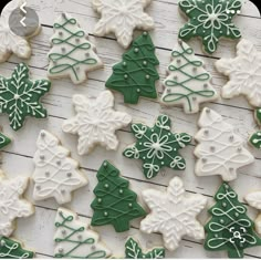 christmas cookies decorated with green and white icing are on a table next to each other