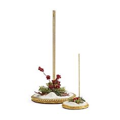 two christmas decorations are sitting on top of a white surface with red berries and greenery