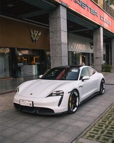 a white sports car parked in front of a building