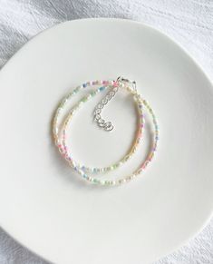 two bracelets sitting on top of a white plate