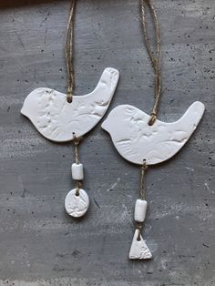 two white ceramic birds hanging from strings