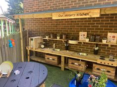 an outdoor kitchen made out of pallets and wooden crates with plants on the shelves