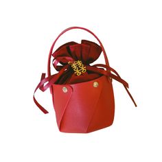 a small red bag with a bow on the top and handles, sitting in front of a white background