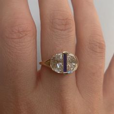 a woman's hand with a ring on it and an oval shaped diamond in the middle