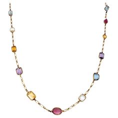 Long, luxurious multi-gemstone station necklace bursting with color. This amazing piece absolutely lights up the neck! Featuring 21 assorted bezel set gemstones on an elongated link chain, the colorful stones pop against the warm yellow gold setting. Shades of pink, blue, purple, yellow, orange and green radiate throughout the piece, each a different shape and hue. This necklace can be dressed up or down and adds the perfect pop of color to your look. The long piece can also be wrapped around th Asymmetrical Jewelry, Purple Yellow Orange, Multi Gemstone Necklace, Colorful Stones, Bezel Necklace, Color Jewelry, Gold Long Necklace, Warm Yellow, Gem Necklace