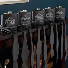 six flasks are lined up on a table with black ribbons hanging from them