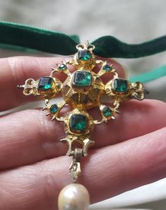 I always maintain that a cross is a dramatic piece of jewellery. This one is high grade silver (unmarked and tested) and is gilded in gold. The pendant is 2 1/4 inches long by 1 3/4 inches wide. It is beautifully designed with emerals green flat cut pastes and had a pearl drop. The bubble back it typical of this period and the gold gilding has worn with centuries of wear. The center stone is cracked but appears to be stable. C. 1720 and Spanish. Follow me on instagram2jettesjewels. Elegant Cross Collectible Jewelry, Elegant Cross Jewelry For Collectors, Luxury Crucifix Cross Necklace For Formal Occasions, Luxury Formal Cross Pendant Necklace, Gold Crucifix Jewelry Collectible, Collectible Gold Crucifix Jewelry, Antique Yellow Gold Crucifix Jewelry, Antique Cross Necklace For Jewelry Making, Collectible Cross-shaped Jewelry With Large Pendant