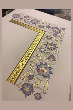 a piece of paper that has been cut out with gold and blue flowers on it