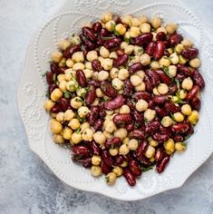 a white bowl filled with red beans and green garbanzons on top of a table