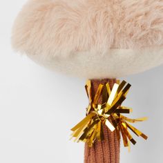 a close up of a stuffed animal on a white surface with gold foiling around it