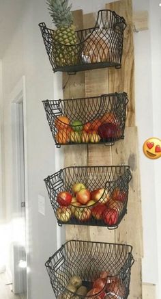 three metal baskets filled with fruit sitting on top of a wooden shelf