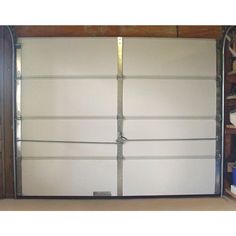 an open garage door with metal bars on the sides and white doors, in front of a bookshelf