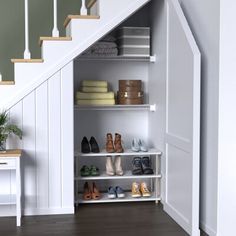 an open closet under the stairs with shoes and other items on shelves next to it