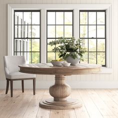 a dining room table with two chairs and a potted plant in the center on top