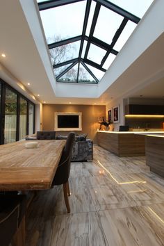 a dining room table with chairs and a skylight in the middle of it's ceiling