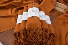 two brown scarfs with white tags on them