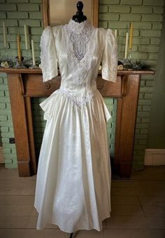 a white dress on display in front of a fireplace