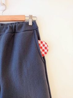 a pair of blue pants with a red and white checkered heart pinned to them