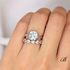 a woman's hand with a diamond ring on top of her finger and the word love written in cursive writing