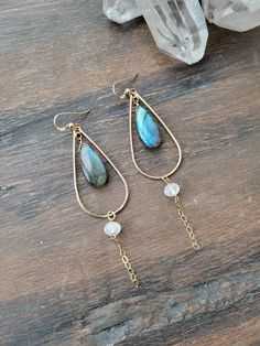 Spellbound Labradorite Earrings with Moonstone. The meaning of spellbound has to do with having your attention fixated as though by a spell or magic! When those colors of Labradorite "flash" it is hard not to stare and be in awe of the beauty and magic of the Labradorite Gemstone! Each teardrop hoop is hand formed and lightly hammered for texture and shape. The length is just a little over 3 in. Each Labradorite is unique, natural, and will vary in color. Some are bluish, greenish, yellowish/orange, or a mix. Please see the 5th picture to see some of the variations. If you have a preference, please message me and I will do my best to accommodate. At the top of the chain is a beautiful petite Moonstone gem. Each piece is handmade and may vary slightly. Thank you! Labradorite Earrings, The Meaning, Earring Necklace, Moonstone, Labradorite, Gold Filled, The Beauty, Flash, Gems