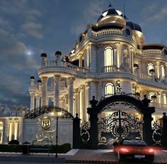 a car is parked in front of a large building with lights on it's sides