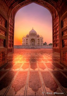 an archway leading to the tajdar palace in india at sunset with pink and purple hues