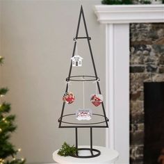 a small christmas tree sitting on top of a white table next to a fire place