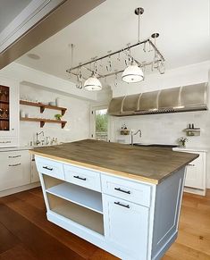 a large kitchen with an island in the middle and lots of cupboards on both sides