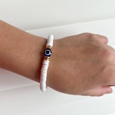 This Handmade Bracelet Is Made With Clay Beads And A Bright Blue Evil Eye Bead. Perfect For Any Occasion And Style! White Letter Beads Jewelry For Beach, Beach Jewelry With White Letter Beads, Handmade White Stretch Bracelet For Vacation, White Beach Jewelry With Letter Beads, White Letter Beads Bracelets For Beach, White Hand-strung Bracelets For Beach, White Bracelets With Letter Beads For Vacation, Handmade White Bracelets For Vacation, White Letter Beads Bracelet For Vacation