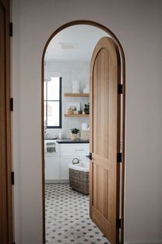 an open door leading to a kitchen with white cabinets