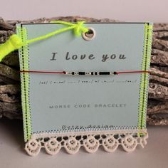 a small card with a string attached to it that says, i love you more code bracelet