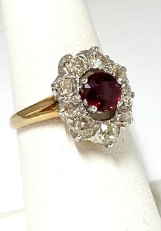 This is a one of a kind ruby and old diamond ring in 14K yellow gold and platinum. The center ruby measures 6.14mm x 5.78mm and is approximately 1.09ct.  It has a halo of both old mine cut and old European cut diamonds measuring from 2.85mm to 3.75mm with an estimated weight of 1.50ctw.   The ring weighs 5.60 grams. This would make a fabulous alternative engagement ring, special gift or July birthday gift. It is a size 7 and we can size it at no charge to you. Vintage Ruby Diamond Ring Stamped 14k, Vintage Ruby Diamond Ring In 14k Gold, Victorian Ruby Ring With Diamond Center Stone, Vintage Ruby Diamond Ring, Antique Ruby Diamond Ring With Center Stone, Diamond And Ruby Ring, Pretty Accessories, Old Mine Cut Diamond, July Birthday