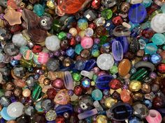 many different colored glass beads are scattered together