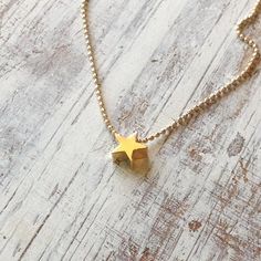 A petite tiny beautiful shiny gold star necklace pendant .Very tiny necklace elegant and cute, a perfect gold necklace for every day wear. Simple, dainty and classic! Necklace Measures Approximately 17"Made from 14k gold filled chain and lobster claps You can adjust the size on request.All my jewelry are packed in an elegant gift box.If you want to give it as a gift you can specify the address and I'll be happy to send it on your behalf.To see more, please visit my shop at :  http://www.etsy.com Dainty Yellow Gold Star Charm Necklace, Dainty Star Charm Necklaces, Dainty Star Charm Necklace, Tiny Star Shaped Minimalist Necklaces, Minimalist Star Charm Necklace With Delicate Chain, Dainty Gold Necklaces With Star Charm, Tiny Star Minimalist Necklaces, Minimalist Tiny Star Necklaces, Dainty Star Necklace For Everyday Wear