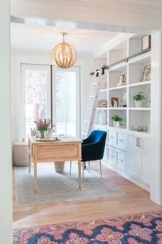 a living room with white walls and blue chairs in the corner, along with a rug on the floor