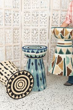 a person standing next to some decorative vases