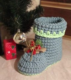 a knitted boot next to a christmas tree