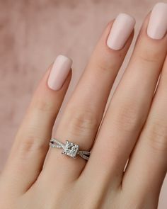 a woman's hand with a ring on her finger and a diamond in the middle