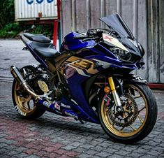 a blue motorcycle parked on top of a brick road